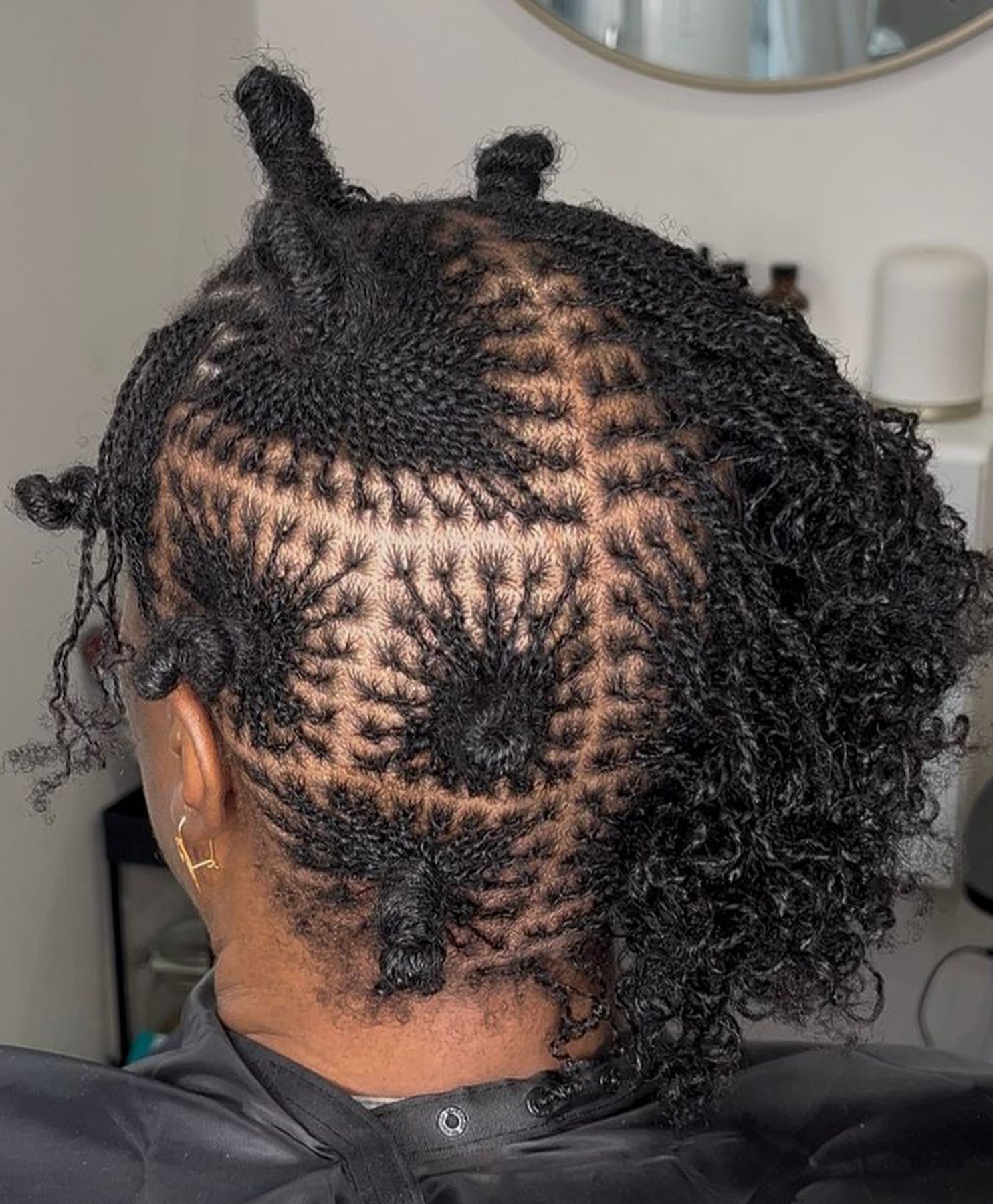 Close-up of a precise sectioning pattern on natural locs being styled at Locs by Hair Arena